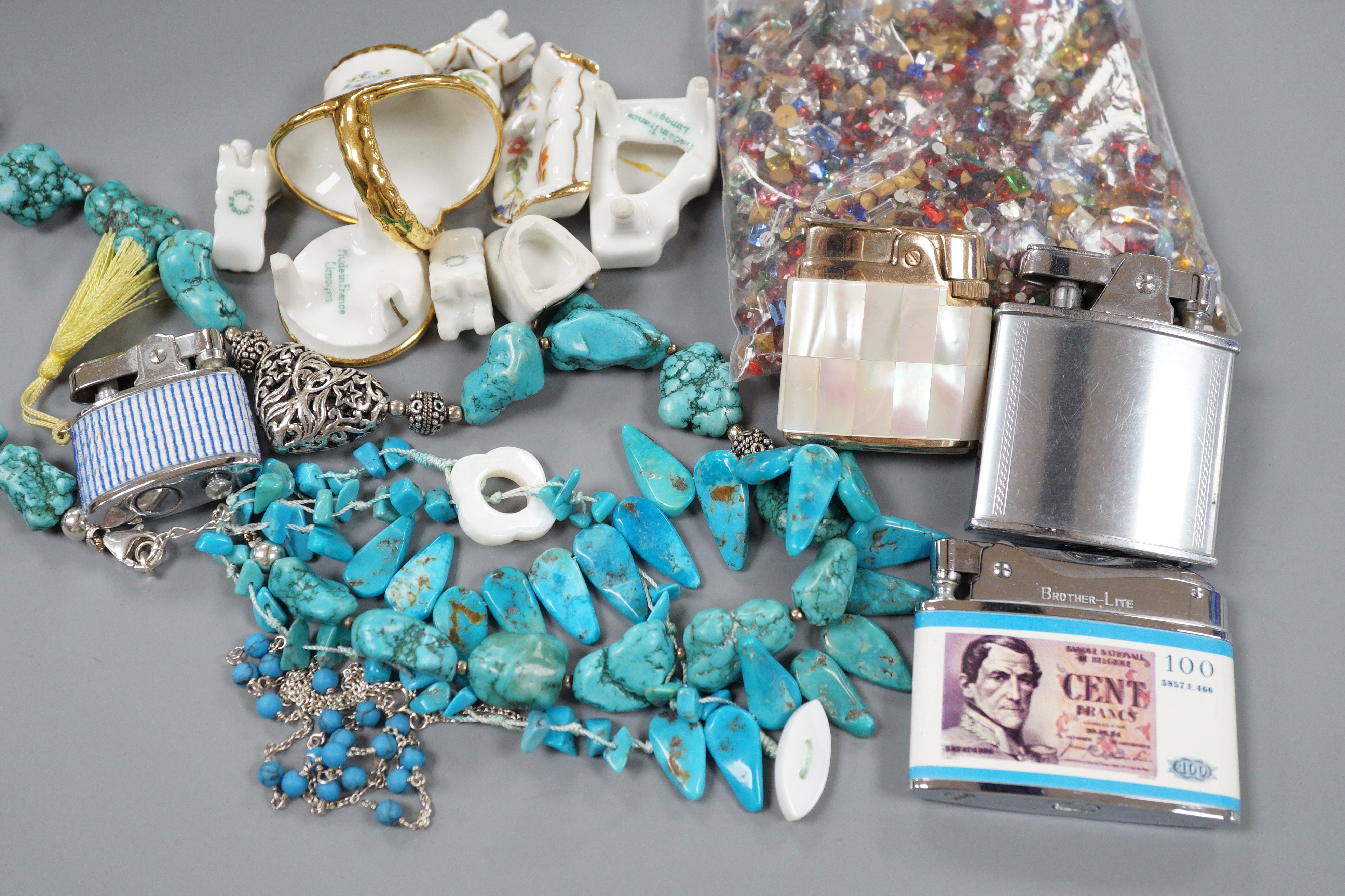 Nine miniature items of Limoges, including furniture, three turquoise necklaces, a group of assorted loose coloured paste stones and four assorted lighters.